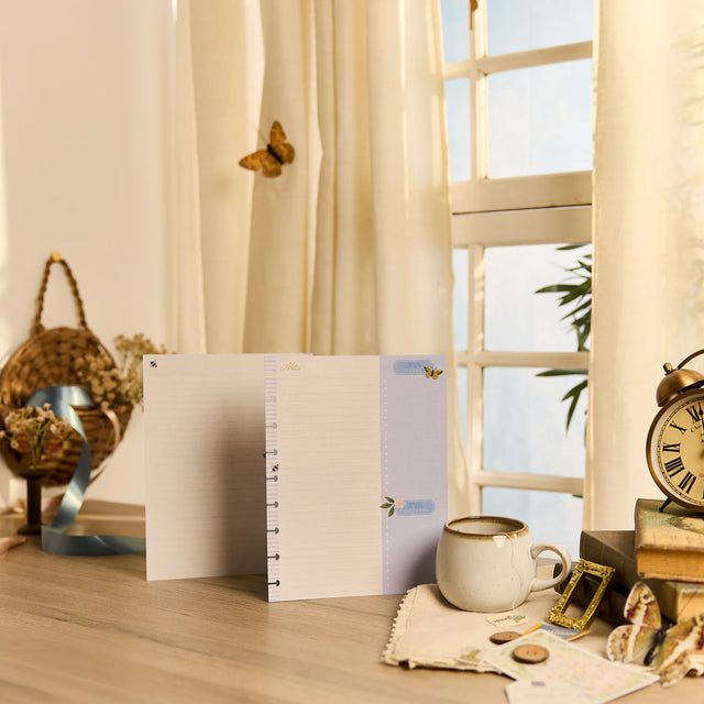 Notebook on a desk with decorative items and a window in the background
