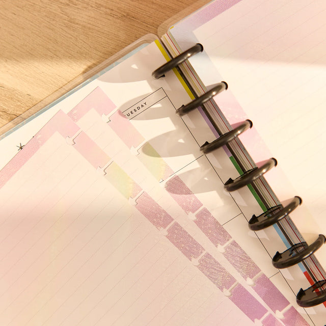 Close-up of a planner with colorful tabs on a wooden surface