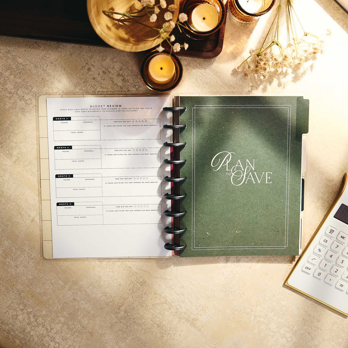 Open Amber & Oak budget journal with a review page beside a green divider and calculator