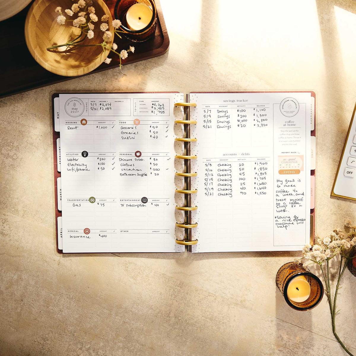 Amber & Oak handwritten budget entries and gold discs on a desk
