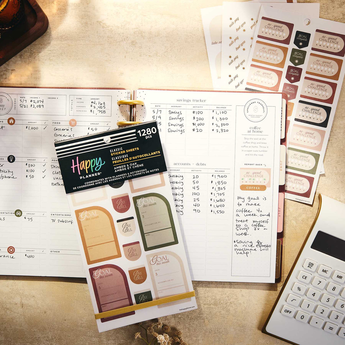Amber & Oak Budget sticker book on an expense tracking spread with sticker sheets and a calculator