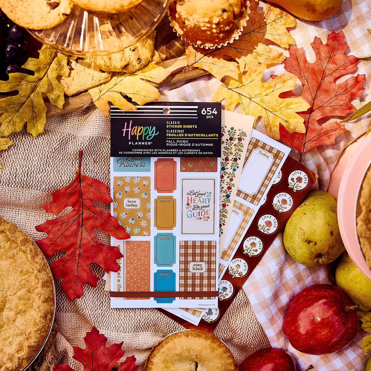 Fall Picnic sticker book and decorative sheets on a picnic cloth surrounded by autumn leaves, fruit and baked treats