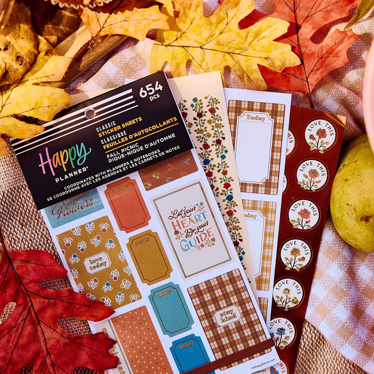 Fall Picnic sticker book and floral sheets on a checked picnic cloth surrounded by autumn leaves