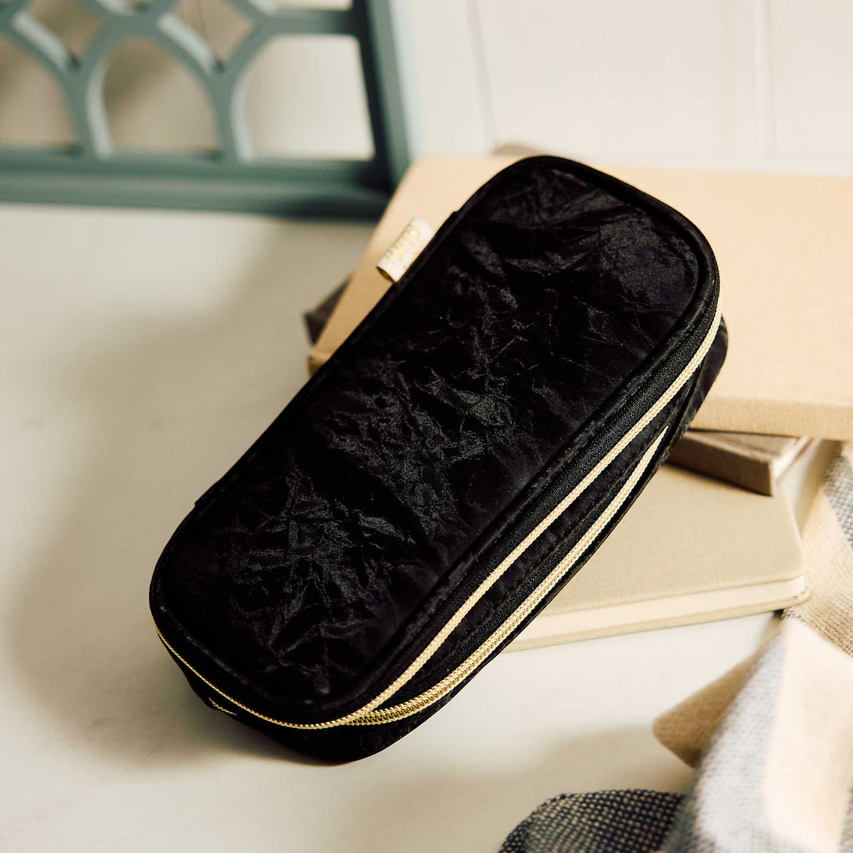 Happy Planner Onyx pouch with double zips resting on stacked notebooks