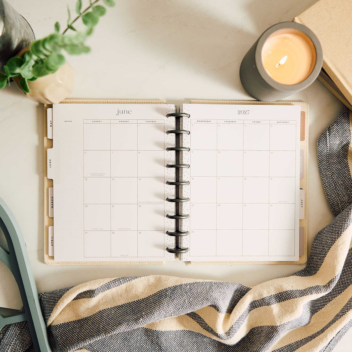 Haven & Heart planner monthly spread beside a candle and greenery