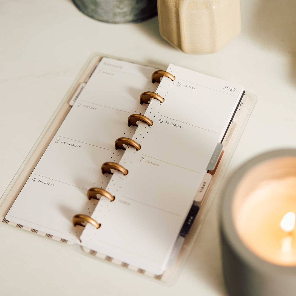 Happy Planner Haven and Heart Skinny Mini weekly pages beside a candle