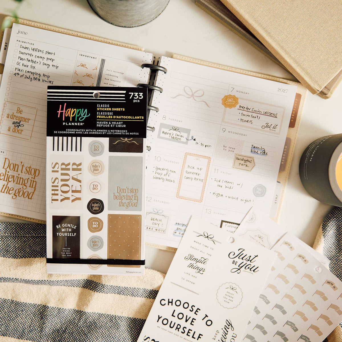 Haven & Heart sticker sheets beside an open planner with decorative and motivational designs