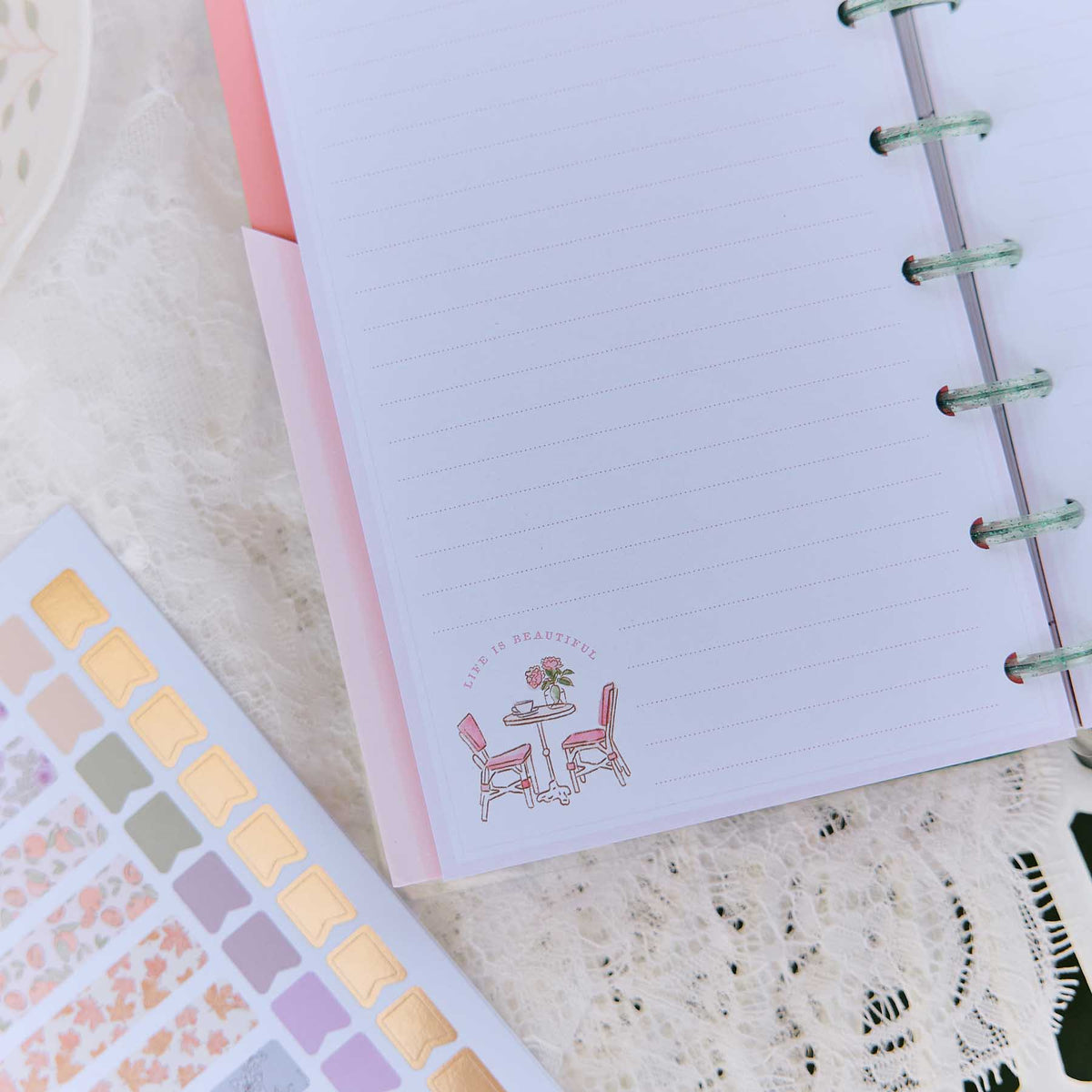 Happy Planner Seasonal Sidewalks stickers beside a lined page with a sidewalk cafe