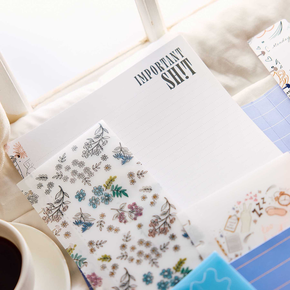 Pajama Plans lined planning page with floral stickers beside a coffee cup