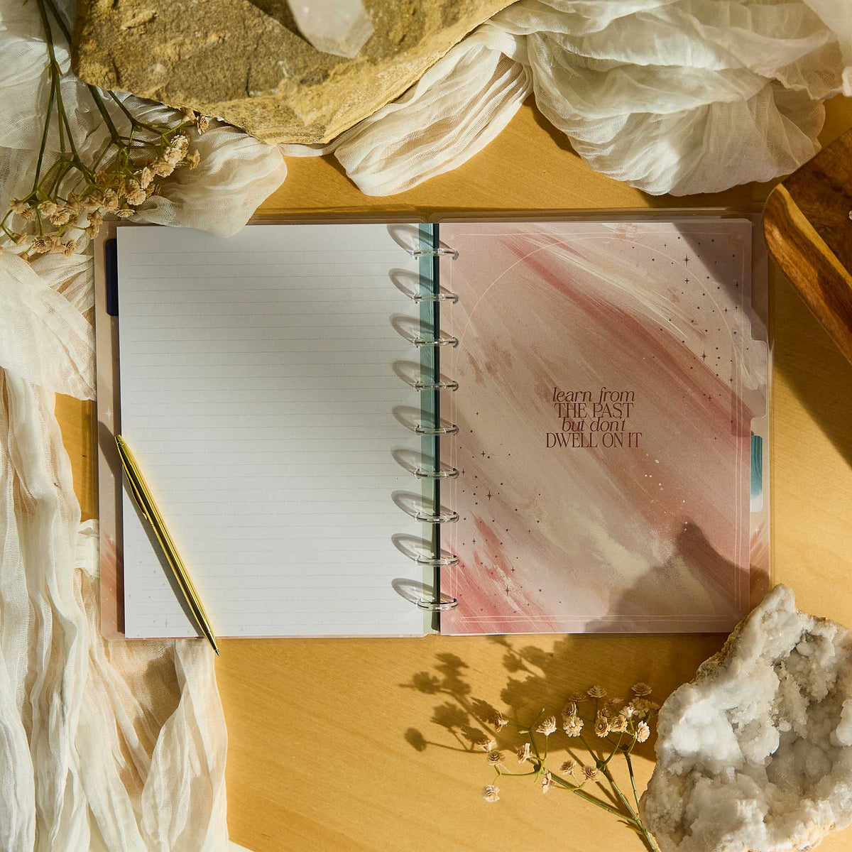 Open Starlit Glow notebook with a pink cover on a wooden surface