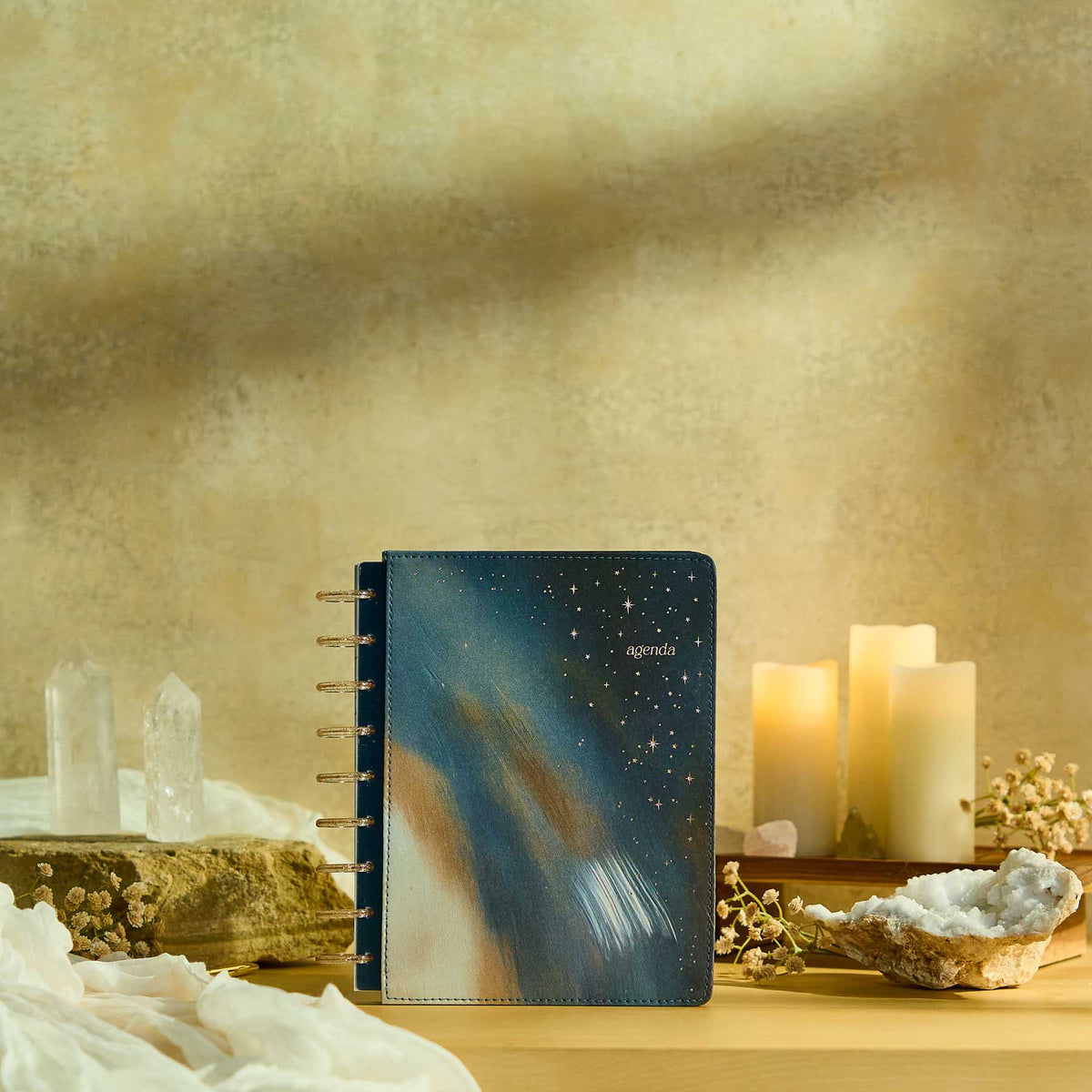 Starlit Glow planner blue starry cover beside candles and crystals