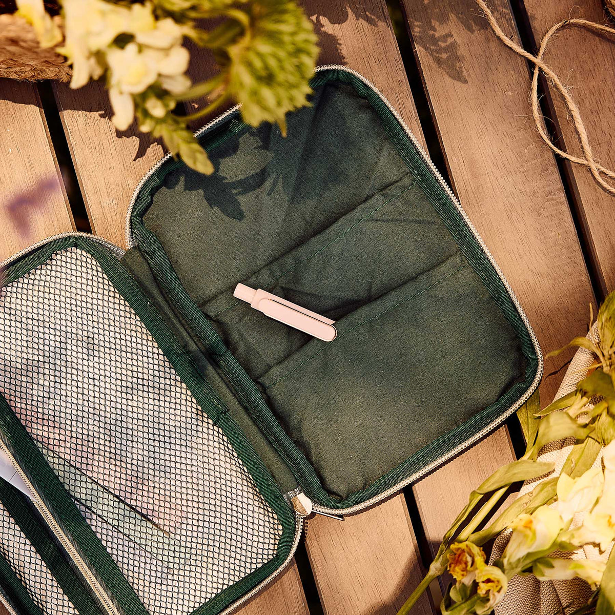 Butterfly zip pouch open with green compartments, mesh pocket and pink pen