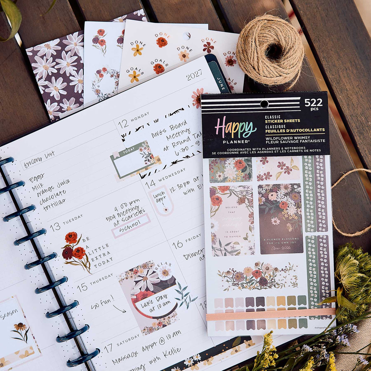 Wildflower Whimsy sticker book and floral sheets beside an open disc-bound planner decorated with flowers and labels