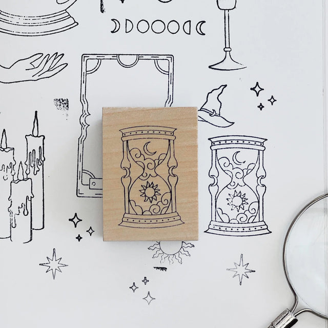 Rubber stamp with hourglass design on a white background with black line art illustrations.