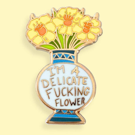 I'm A Delicate Fucking Flower Lapel Pin gold-colored enamel lapel pin featuring a stylized flower vase with flowers and the text 'I'm A Delicate Fucking Flower'.