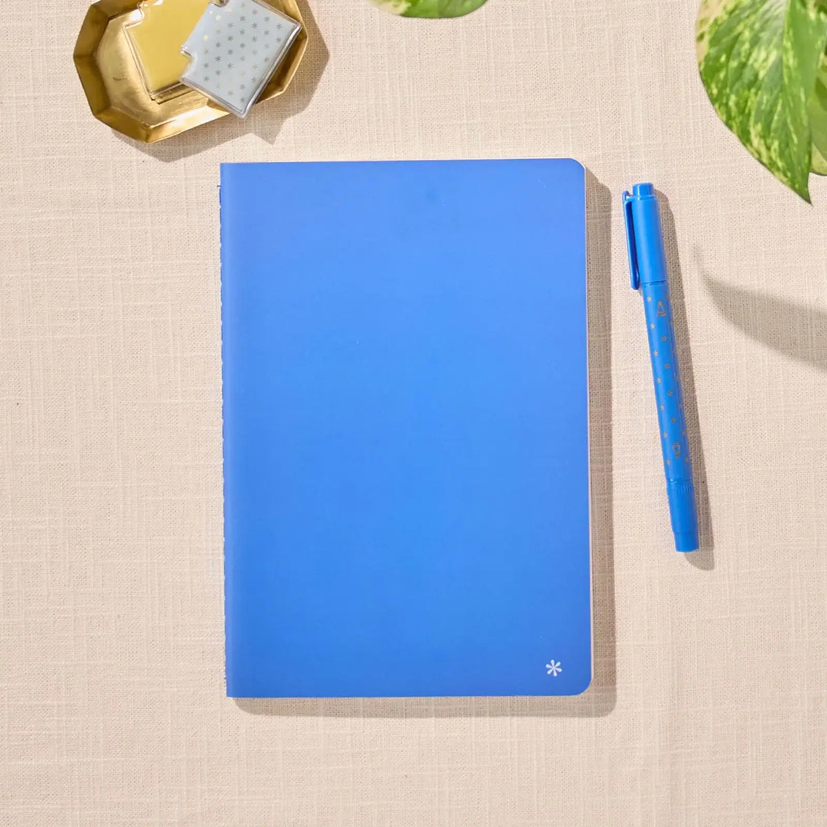 Erin Condren Petite Journal: Closed Royal Blue journal beside a blue pen