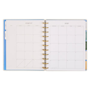 Open planner showing August 2026 layout with gold binding on a white background
