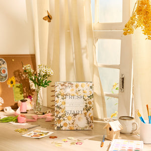 Decorative wellness planner with floral design on a desk with stationery items