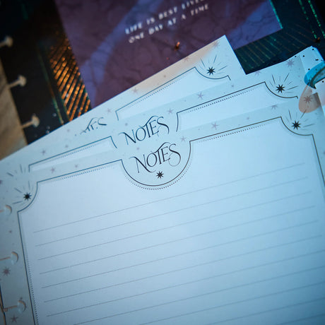 Notebook with 'Notes' heading on a blurred cityscape background