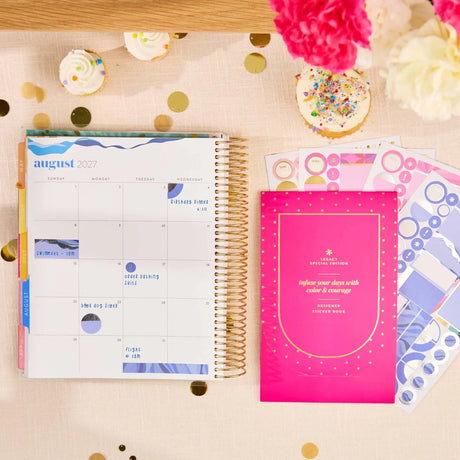 Erin Condren sticker book: Sticker book beside an open decorated planner