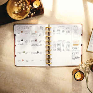 Amber & Oak handwritten budget entries and gold discs on a desk
