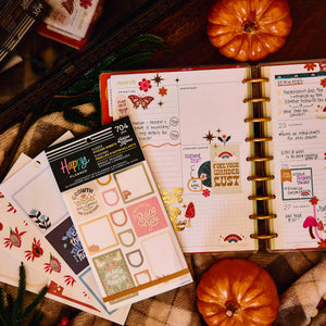 Bright Seasons sticker book beside an open disc-bound planner decorated with seasonal stickers and handwritten plans
