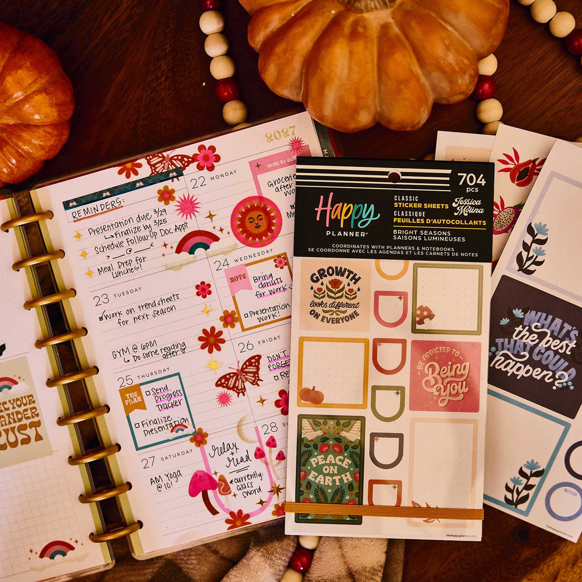 Bright Seasons sticker book and floral sheets on a decorated weekly planner beside pumpkins and a beaded garland