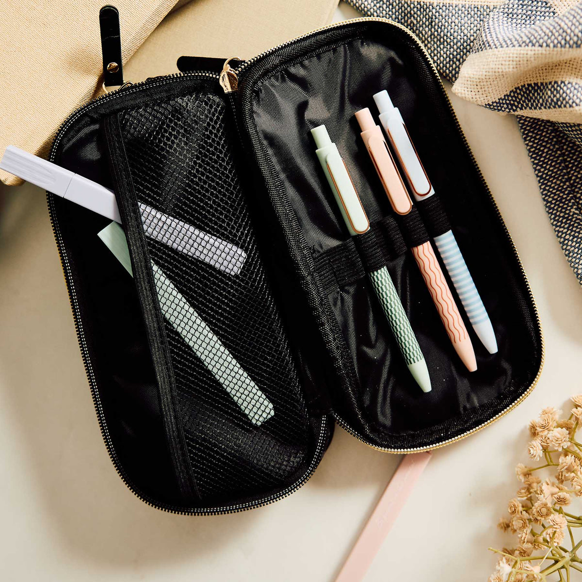 Onyx zip pouch open with colourful pens, mesh pocket and elastic loops