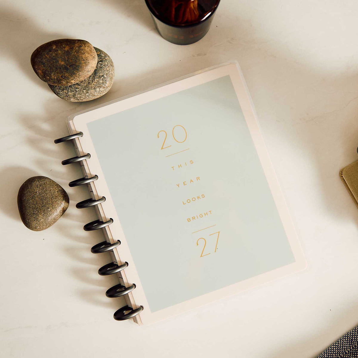 Hushed Hues minimalist planner cover displayed beside stones