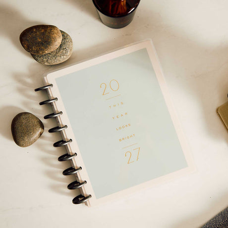 Hushed Hues minimalist planner cover displayed beside stones