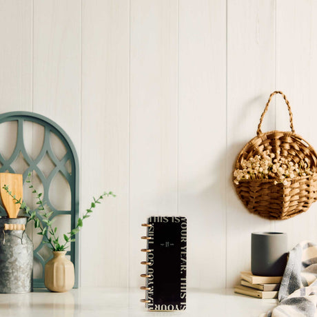 Happy Planner Haven and Heart Skinny Mini black planner displayed beside home decor
