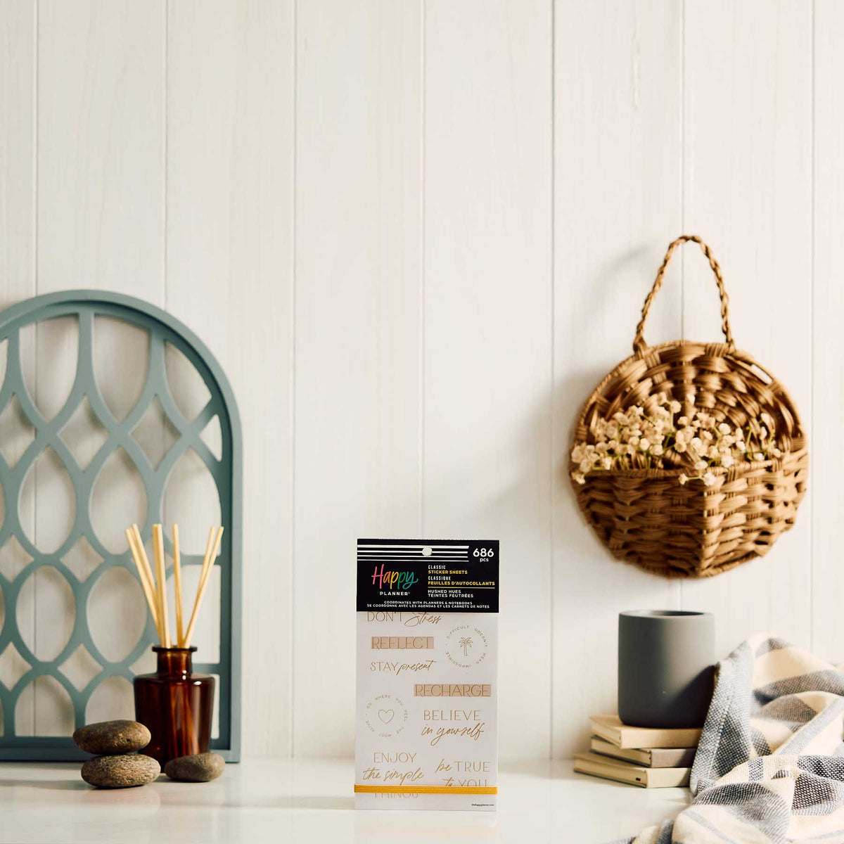 Happy Planner Hushed Hues sticker book displayed beside a mug, diffuser and woven wall basket