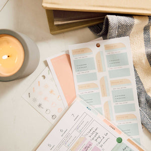 Pastel Hushed Hues reflective prompt stickers beside handwritten planner pages and a candle