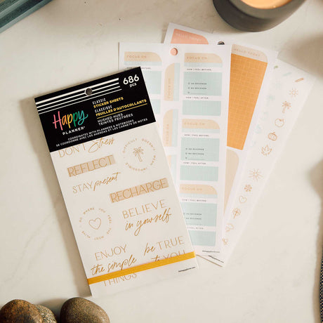 Hushed Hues sticker book and pastel reflection labels arranged beside a candle