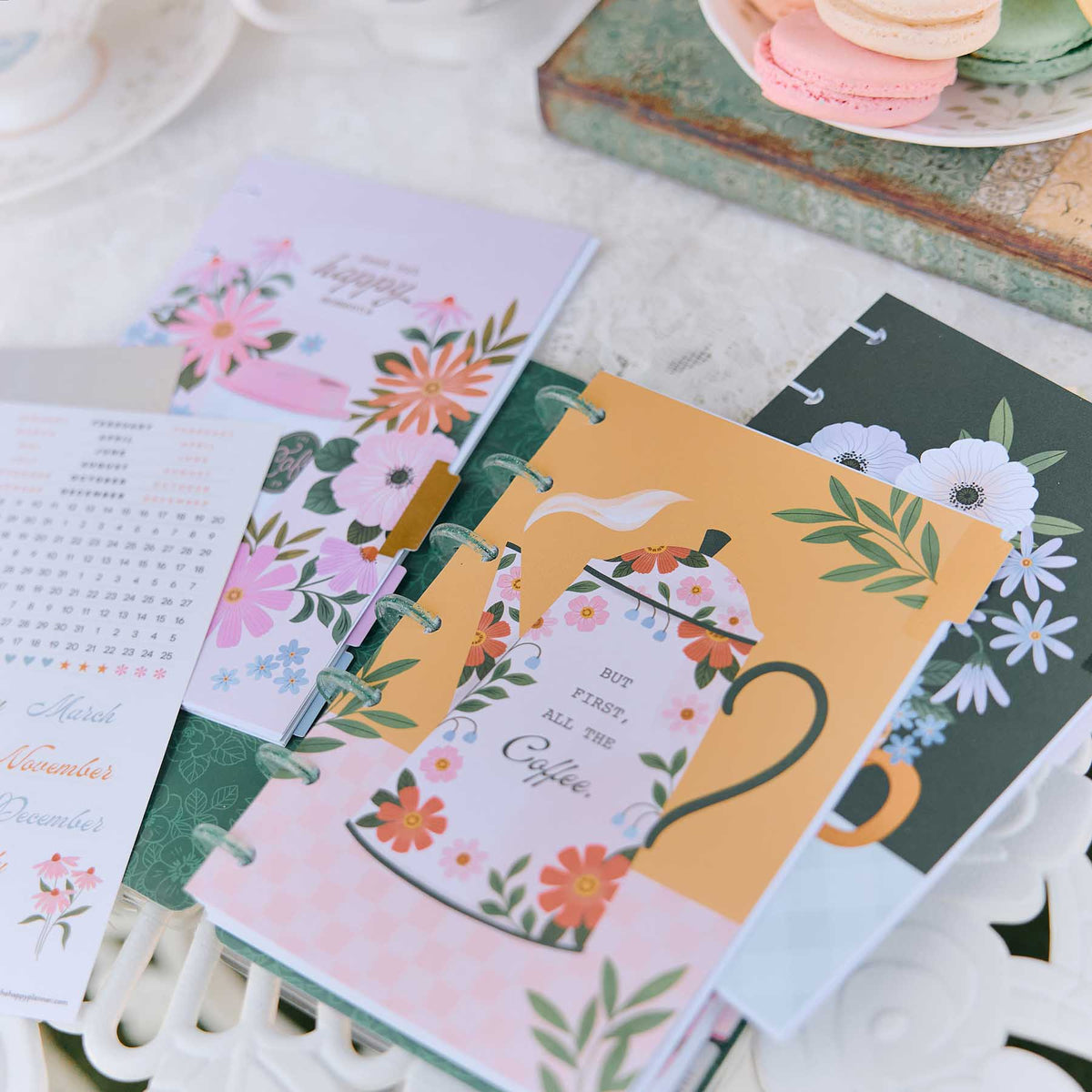 Happy Planner Petal Press floral dashboards and colourful inserts on a desk