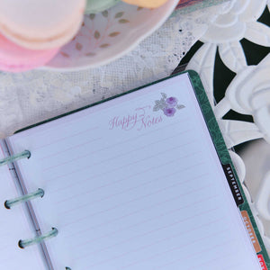 Seasonal Sidewalks Happy Notes page with floral artwork and monthly tabs on a lace-covered table