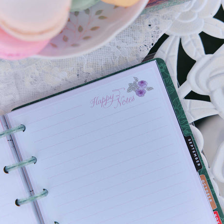 Seasonal Sidewalks Happy Notes page with floral artwork and monthly tabs on a lace-covered table