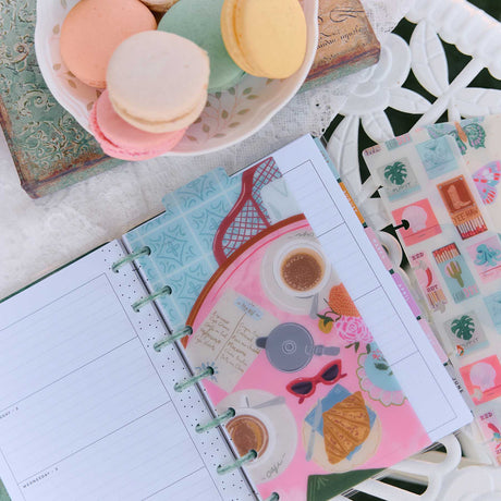 Happy Planner Life In Whimsy Mini dashboards in a pastel planner beside coffee and macarons
