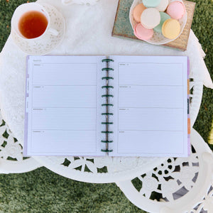 Hive and Bloom Big planner lined weekly spread beside tea and pastel macarons