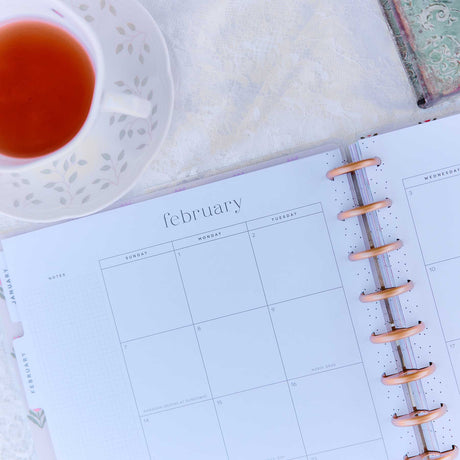 Little Garden Big planner February monthly calendar beside a cup of tea