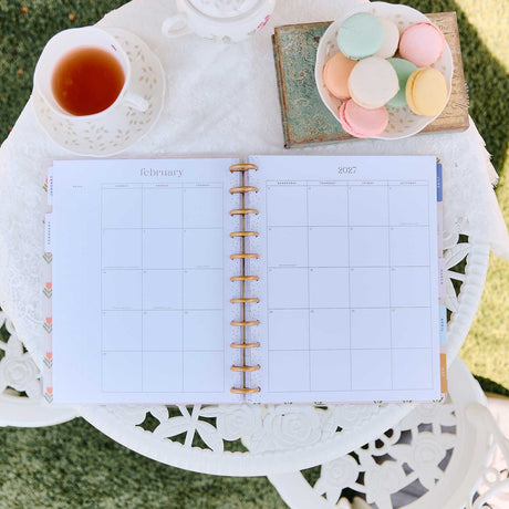 Happy Planner Little Garden February monthly spread beside tea and pastel macarons
