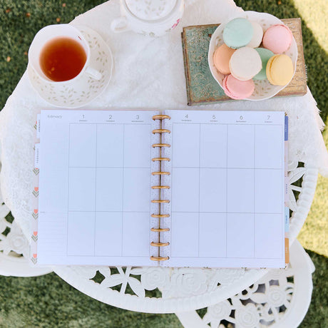 Little Garden Big weekly planner vertical columns beside tea and macarons outdoors