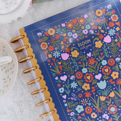 Happy Planner Little Garden blue floral cover and gold discs on a lace table setting