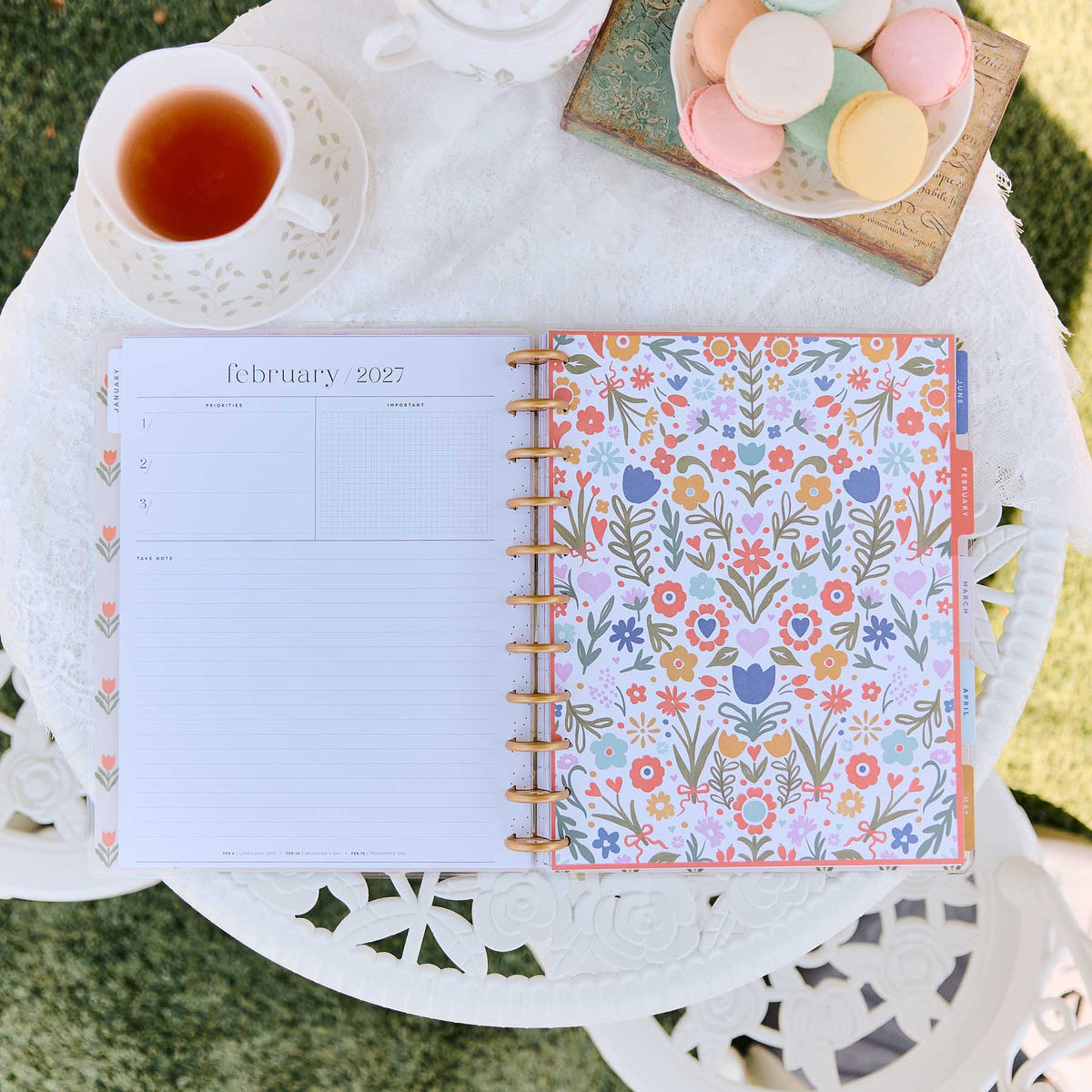 Little Garden planner February 2027 floral pages beside tea and pastel macarons