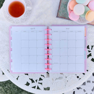 Petal Press monthly calendar with pink discs beside tea and pastel macarons