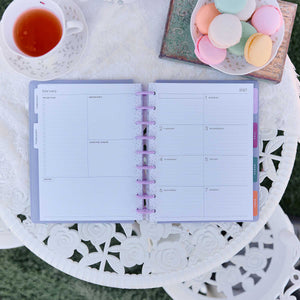 Happy Planner Hive & Bloom Classic Dashboard Planner 2027 - monthly spread beside tea and pastel macarons