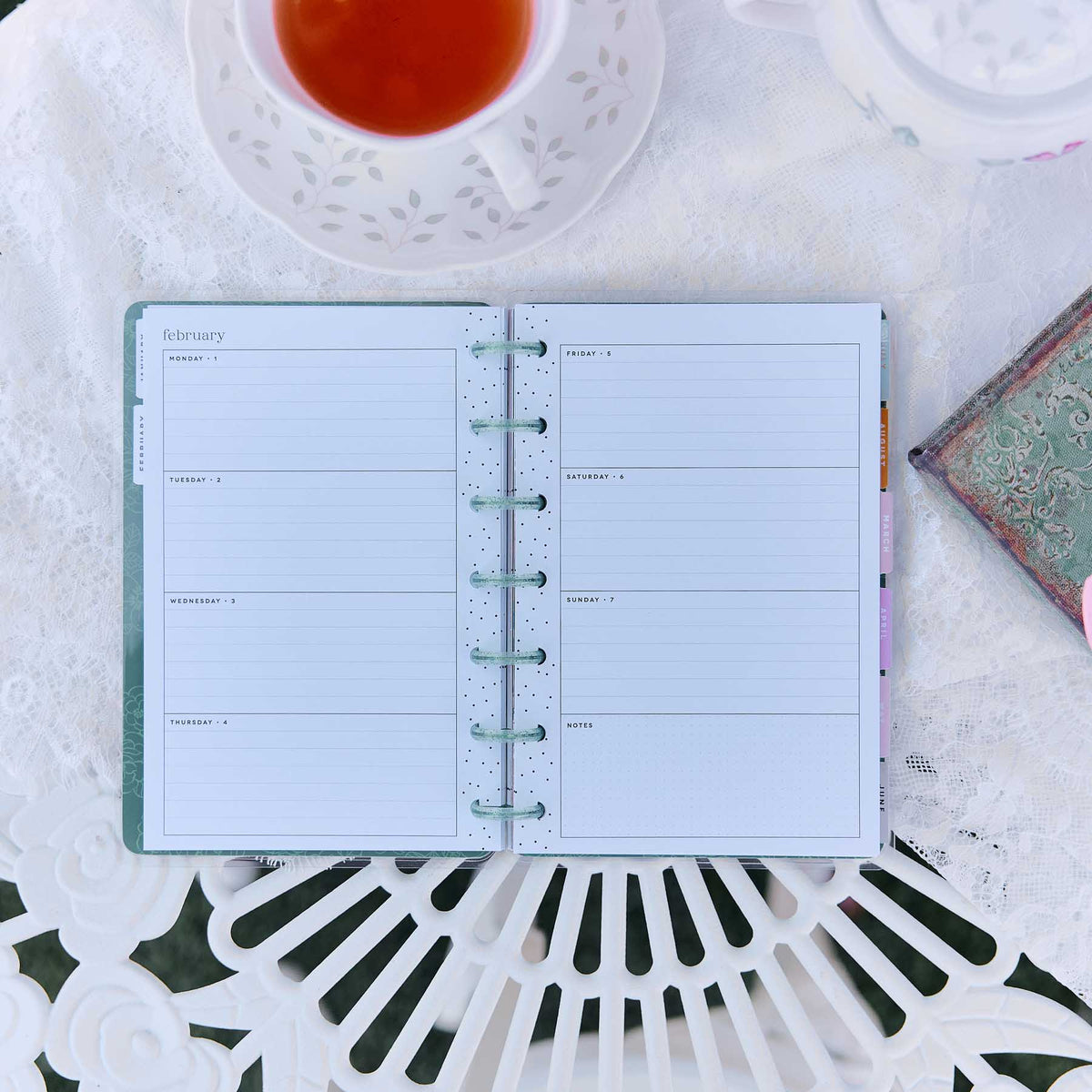 Happy Planner Petal Press lined weekly spread beside tea and a journal