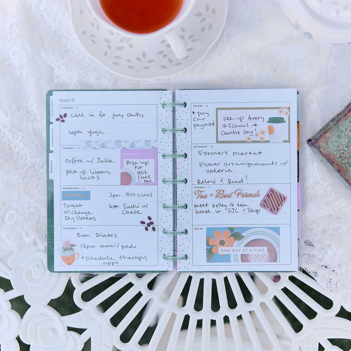 Petal Press Mini planner open with handwritten notes, colourful stickers and disc binding