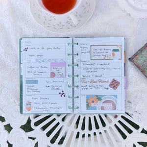 Petal Press Mini planner open with handwritten notes, colourful stickers and disc binding