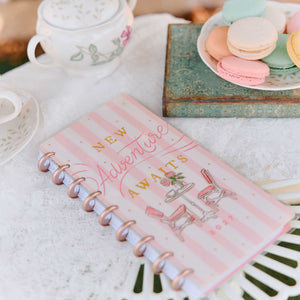 Happy Planner Seasonal Sidewalks pink striped cover beside tea and pastel macarons